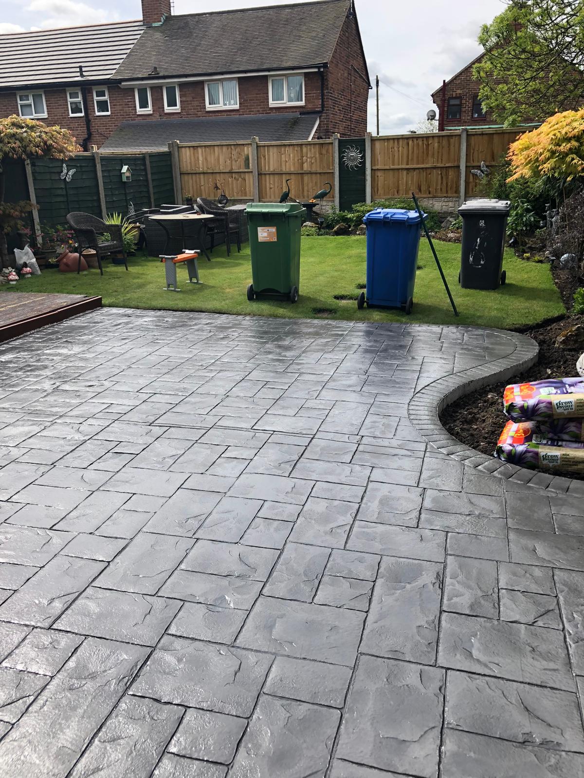 Grey imprinted concrete back garden with curved edging, Warrington, Cheshire